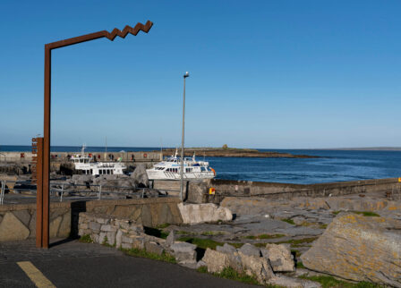 Scenic coastal harbour with boats and clear blue sky.