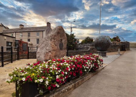 Historic landmark with vibrant flowers at sunset.