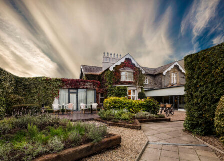 Picturesque rustic hotel courtyard with greenery and cosy outdoor seating.