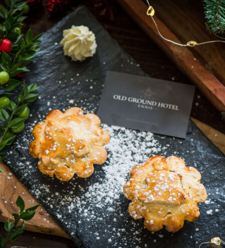 Festive mince pies dusted with sugar at Old Ground Hotel, surrounded by Christmas decor.
