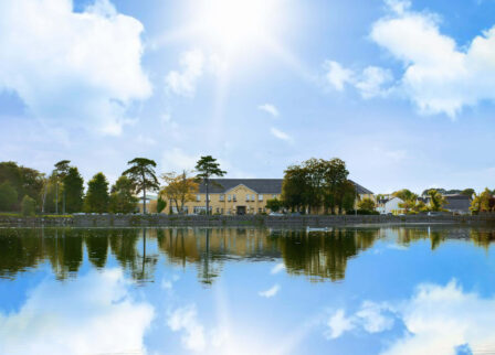 Picturesque lakeside hotel under a bright sky, perfect for relaxing family retreats.