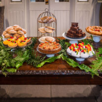 Assortment of pastries and desserts on a wooden table in a cosy, inviting setting.