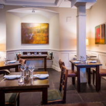Cosy restaurant with elegant tables and warm lighting for a relaxing dining experience.
