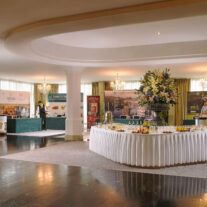 Elegant hotel lobby with event space set for a reception, featuring a buffet table.