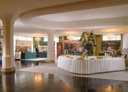 Elegant hotel lobby with event space set for a reception, featuring a buffet table.