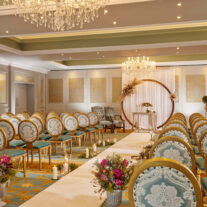 Elegant hotel event room with ornate chairs, floral arrangements, and a large chandelier.